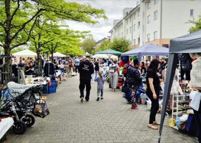 Breiter Marktgang mit Besuchern und Ständen beim Karower Familien-Flohmarkt entlang der Achillesstraße in Berlin-Karow
