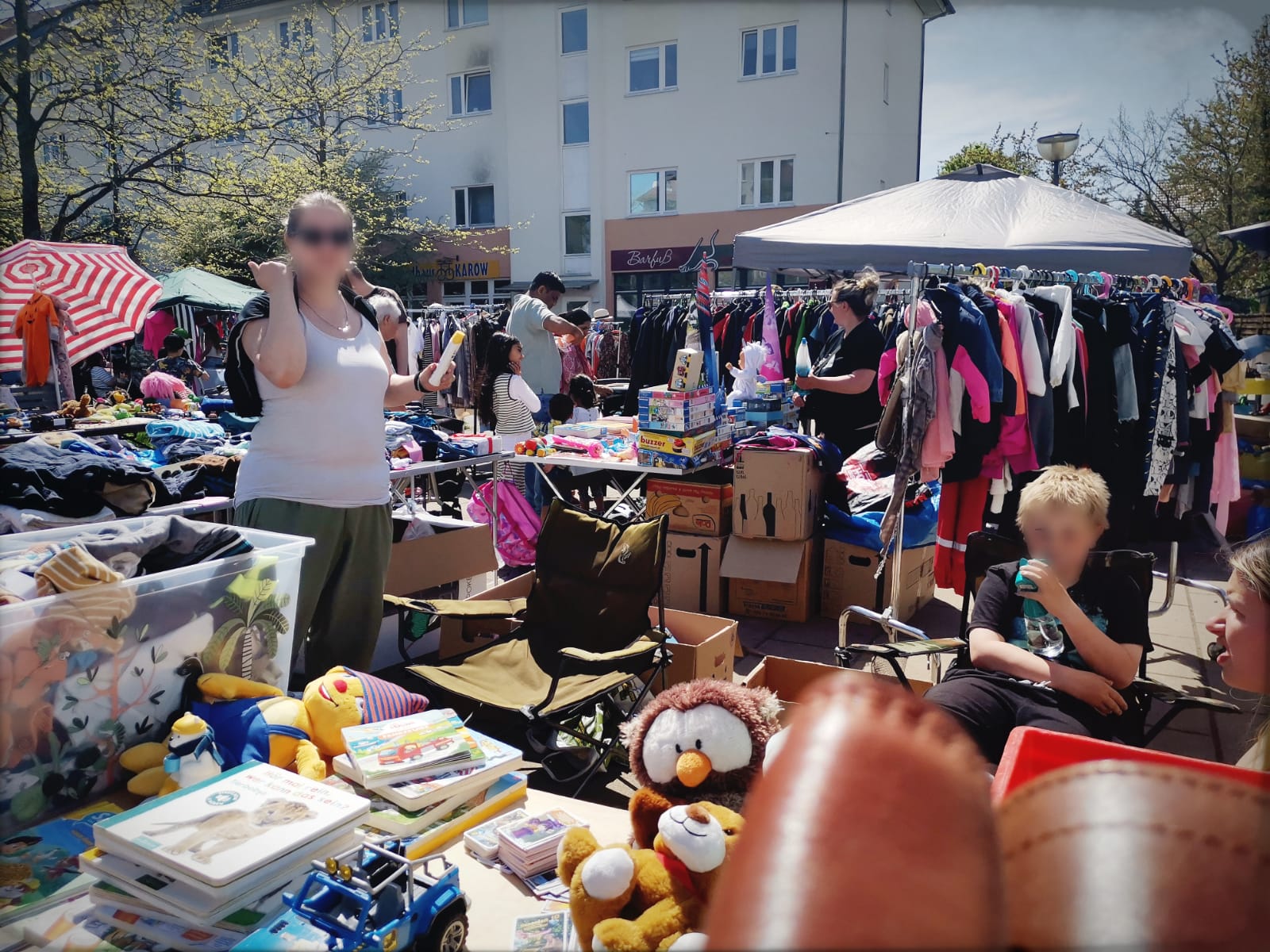 Verkaufsstand mit Spielzeug, Kleidung und Besuchern beim Karower Familien-Flohmarkt in Berlin-Karow
